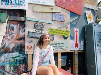 Portrait of smiling woman sitting by text