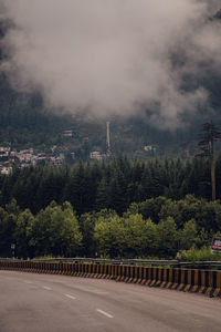 Road amidst trees against sky