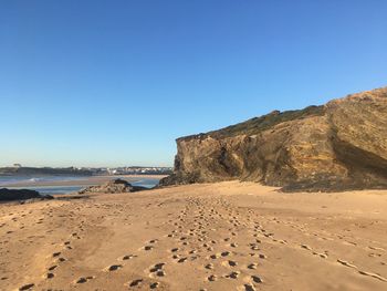 Scenic view of beach against clear blue sky