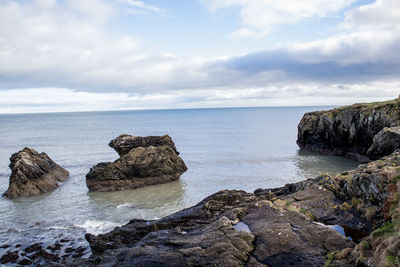 Scenic view of rocks in sea against sky