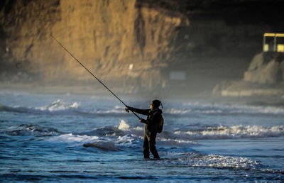 Side view of mature man fishing in sea