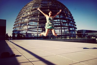 Woman jumping in front of reichstag dome
