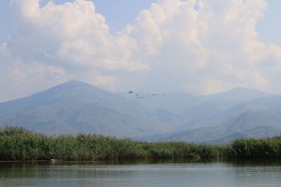 Scenic view of lake and mountains against sky