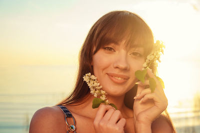 Portrait of smiling young woman against blue sky