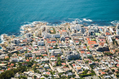 High angle view of cityscape by sea against clear sky