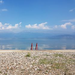 Woman standing on sea shore against sky