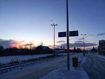Road sign against sky during winter