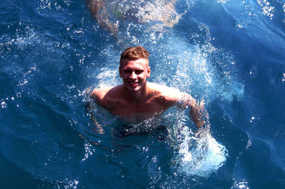 Portrait of young man swimming in pool