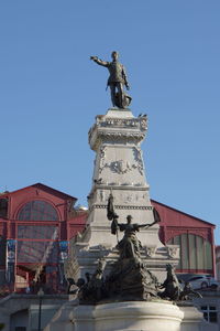 Low angle view of statue against blue sky