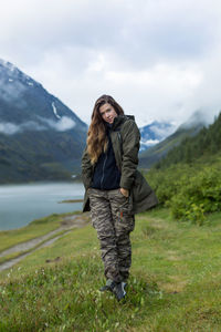 Portrait of smiling woman standing on mountain against sky