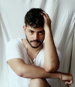 Portrait of young man relaxing on bed at home