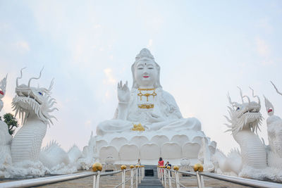 Statue against temple building against sky