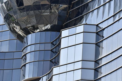 Low angle view of glass building against clear sky