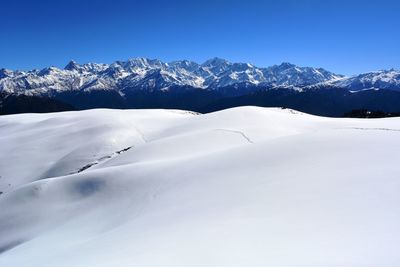 Scenic view of snowcapped mountains against clear blue sky