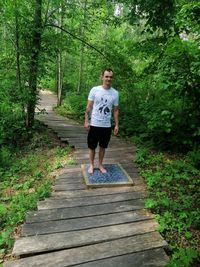 Full length of man walking on footpath in forest