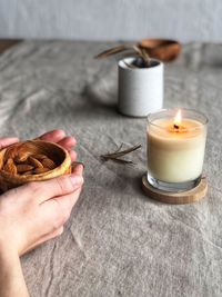 Midsection of person holding drink on table