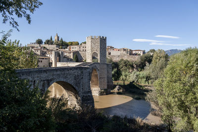 Arch bridge over river against sky