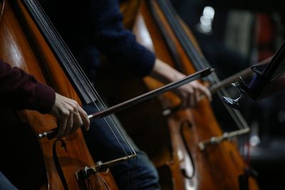 Cropped hands playing double basses