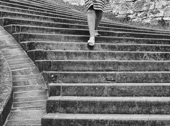 Low section of woman walking on staircase