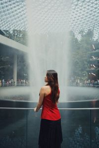 Rear view of woman standing by fountain outdoors