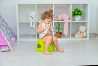 Portrait of cute girl playing with toy on floor at home