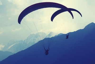 Low angle view of person paragliding against sky