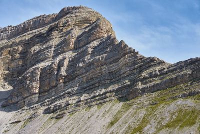 Low angle view of rocky mountains against sky