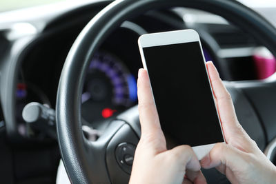 Midsection of man using mobile phone in car