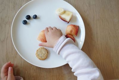 High angle view of hand holding ice cream in plate