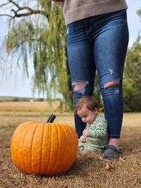 Rear view of boy standing on pumpkin