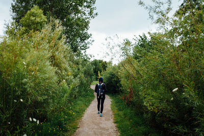 Rear view of woman walking on footpath