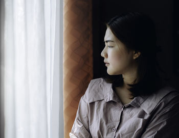 Portrait of young woman looking away at home