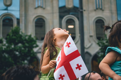 Rear view of two people in front of building