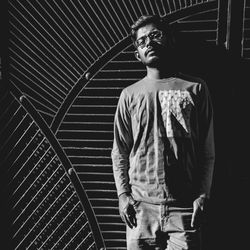 Full length portrait of young man standing against built structure