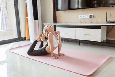 Side view of woman sitting on floor