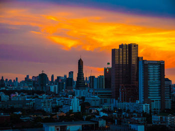 View of cityscape against cloudy sky during sunset