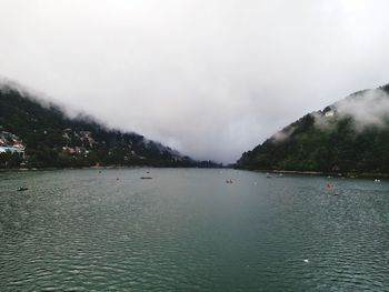 Scenic view of lake by mountains against sky