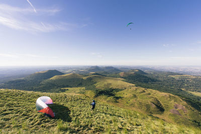 Paragliders at the top of puy-de-dôme with a view of the volcanic massif of the chaîne des puys