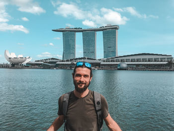 Portrait of smiling man against marina bay sands in city