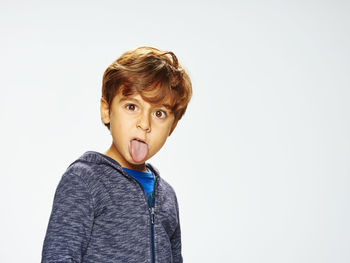 Portrait of boy standing against white background