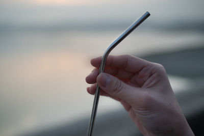 Close-up of hand holding reusable metal straw