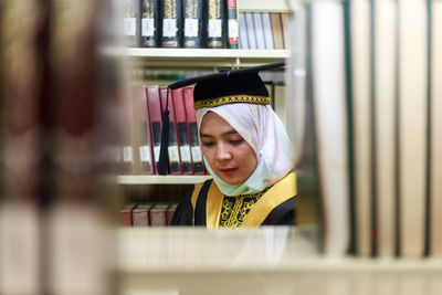 Young woman standing on book at store