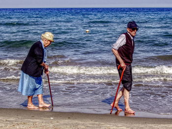 Full length of friends standing on beach