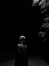 Side view of man standing on footpath at night