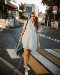 Portrait of young woman walking on street