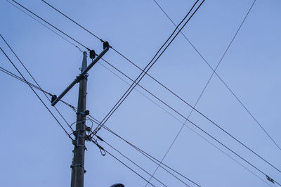 Low angle view of power lines against clear blue sky