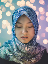 Close-up portrait of young woman against gray background