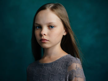 Portrait of young woman against black background