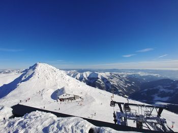 Scenic view of snowcapped mountains against blue sky