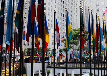 Multi colored flags hanging by buildings in city